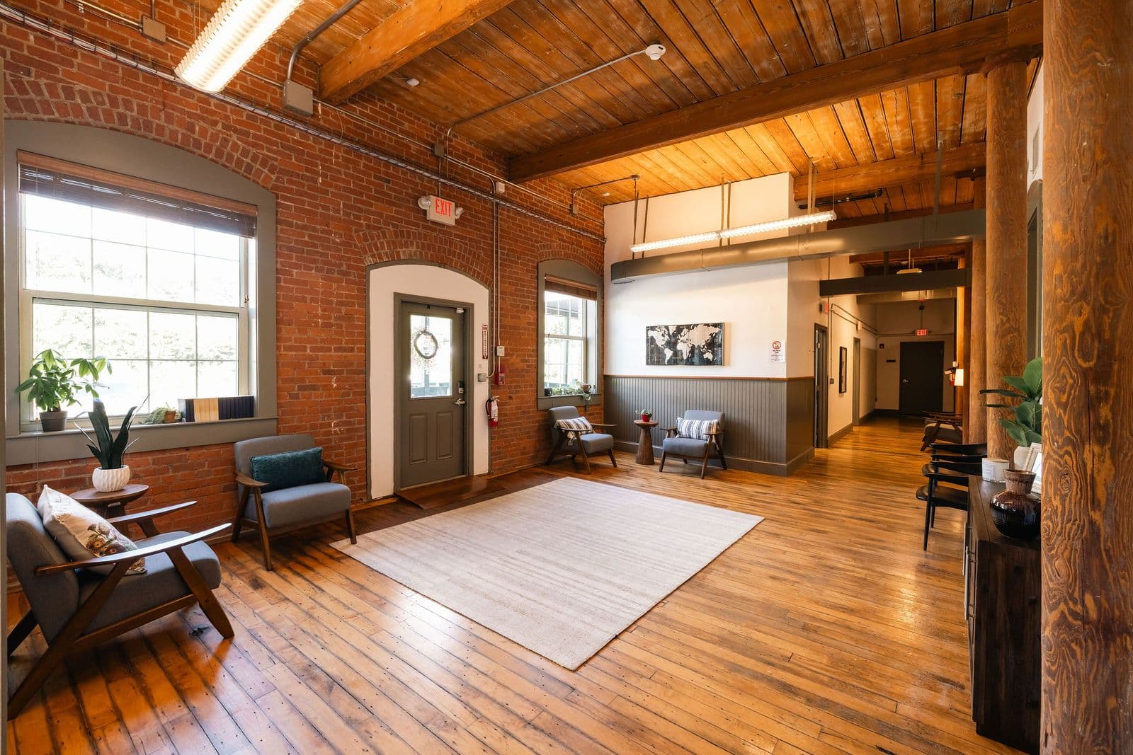 Sunlit client lounge with exposed brick at Lantana Recovery's New Milford, Connecticut center