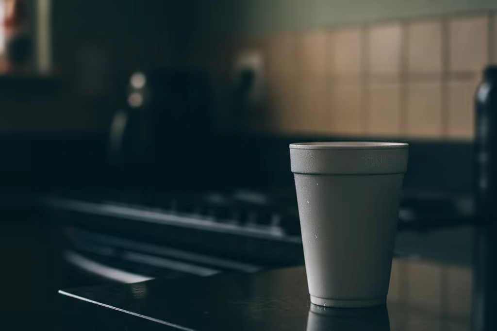 A lone styrofoam cup on a dark kitchen counter in dim evening light
