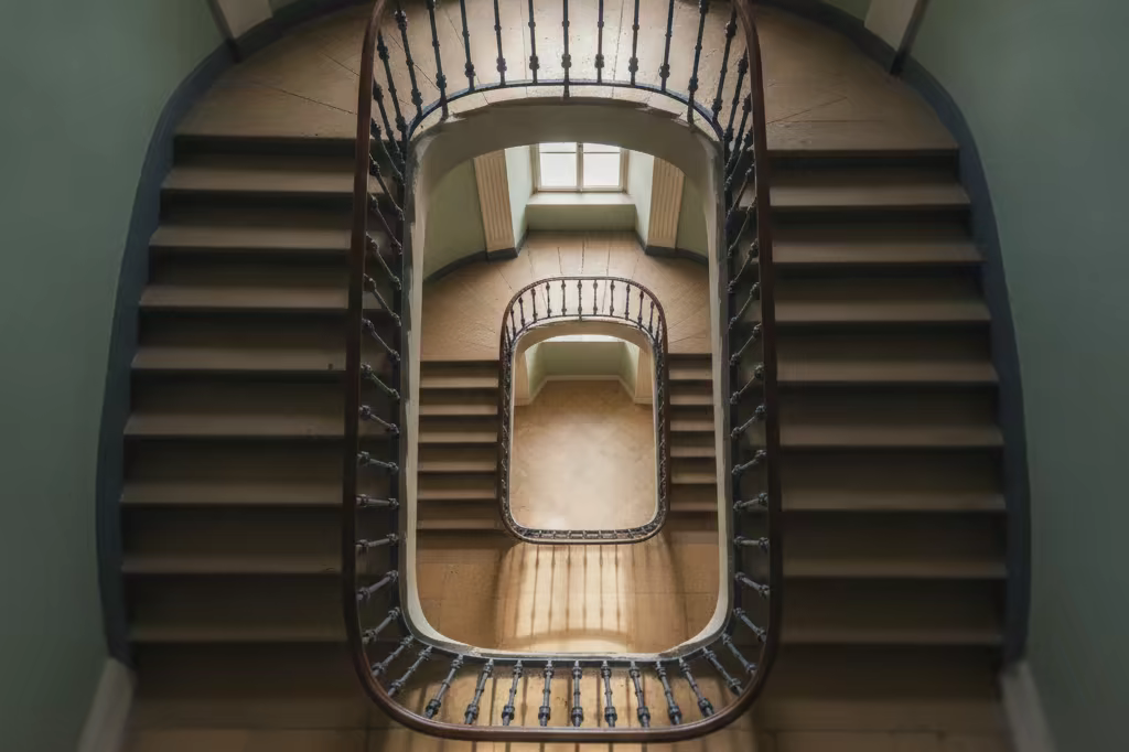 A spiral staircase photographed from below with morning light on the steps