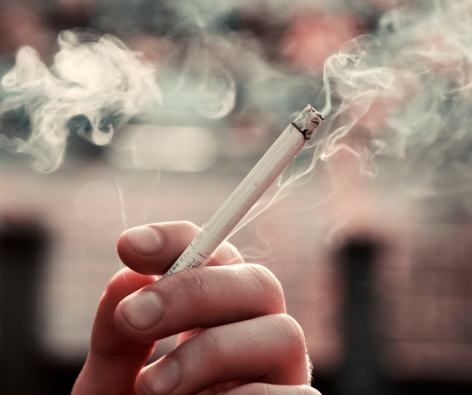 An image showing a person holding a cigarette, representing what is a relapse in the context of stress and addiction.